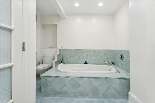 bathroom featuring toilet, tile patterned floors, and tiled tub