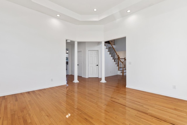 empty room featuring a high ceiling and light hardwood / wood-style floors