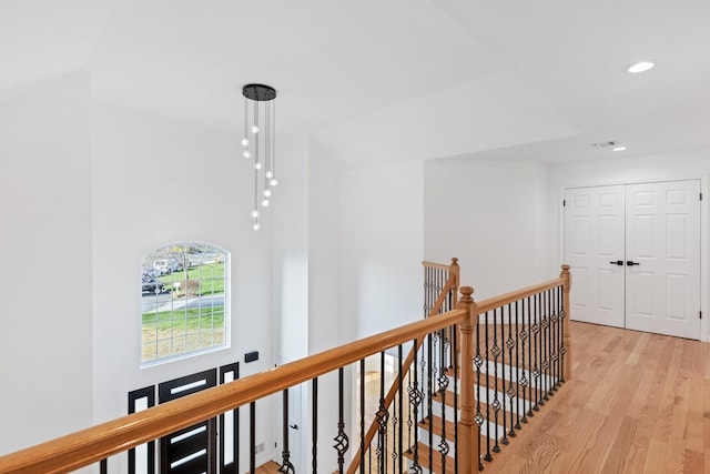 hallway with lofted ceiling and light hardwood / wood-style floors