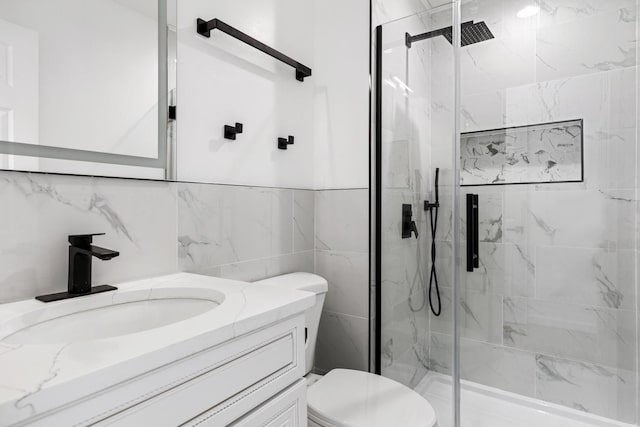 bathroom with a shower with door, tile walls, toilet, and vanity