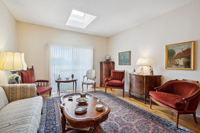 living area with hardwood / wood-style floors and a skylight