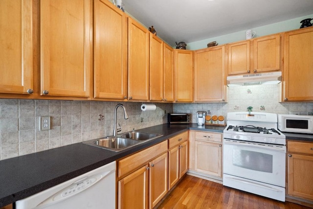 kitchen with decorative backsplash, sink, white appliances, and wood-type flooring