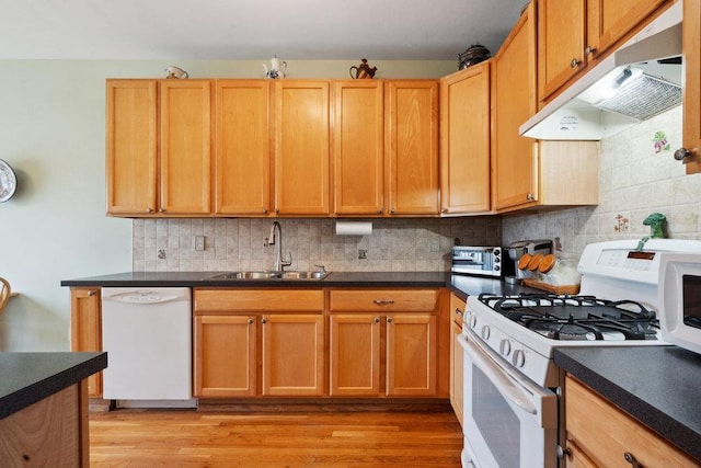 kitchen with backsplash, sink, white appliances, and light hardwood / wood-style flooring