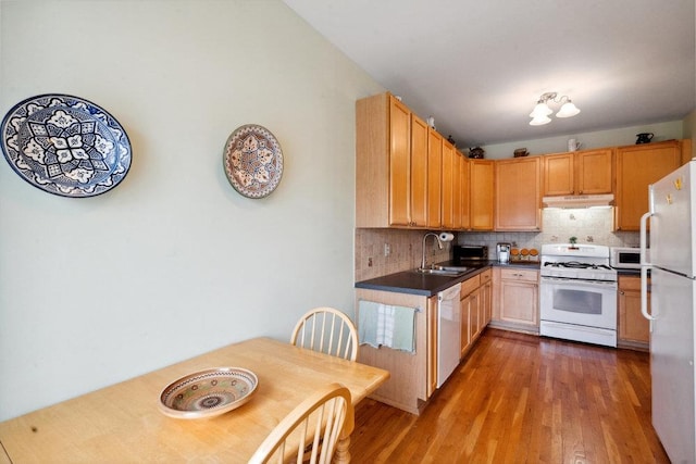 kitchen with backsplash, hardwood / wood-style floors, sink, white appliances, and light brown cabinetry