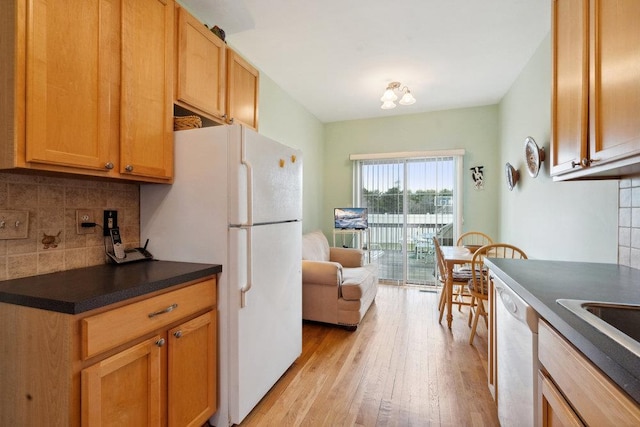 kitchen featuring light hardwood / wood-style flooring, tasteful backsplash, and white appliances