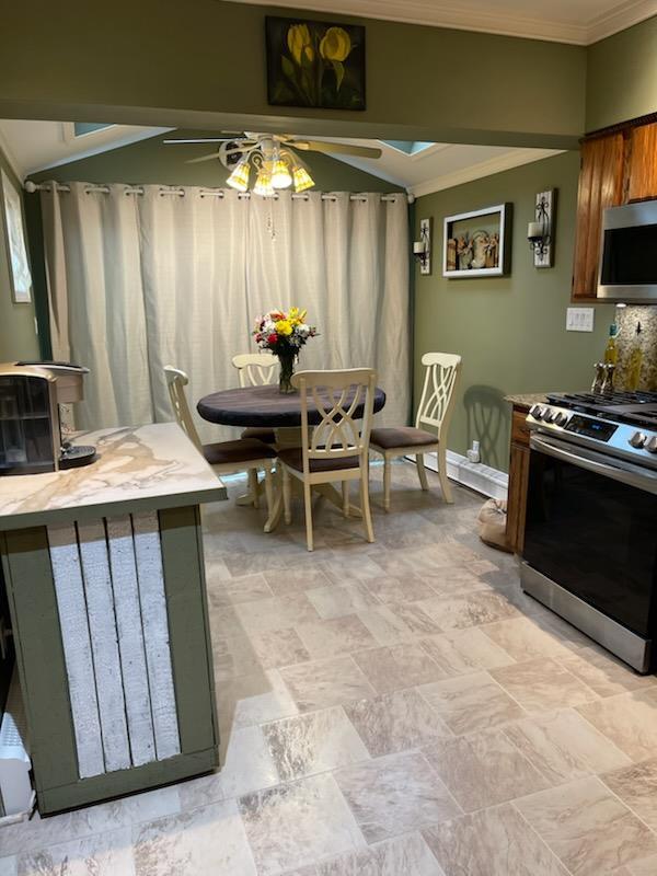 dining area featuring radiator, ornamental molding, and ceiling fan