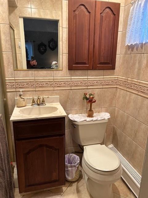 bathroom with tile walls, toilet, and vanity