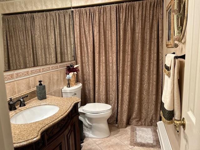 bathroom with tile patterned flooring, tasteful backsplash, a shower with curtain, toilet, and vanity