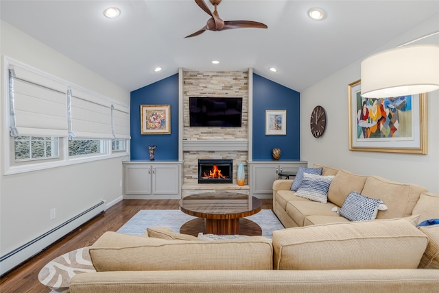 living room with lofted ceiling, hardwood / wood-style floors, a stone fireplace, and a baseboard radiator