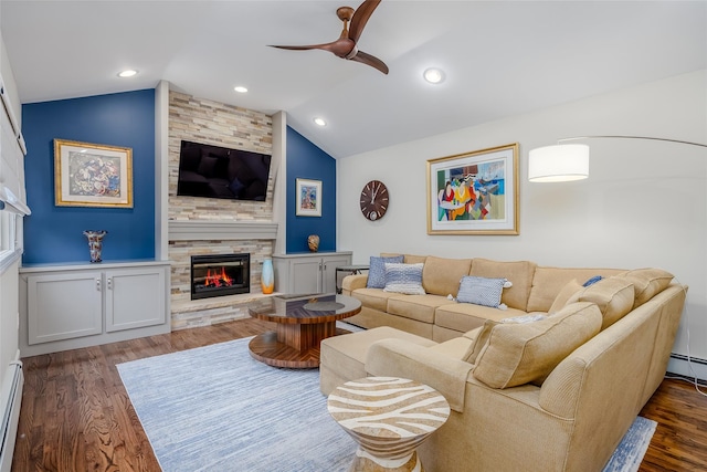 living room with vaulted ceiling, dark hardwood / wood-style flooring, a stone fireplace, and a baseboard radiator