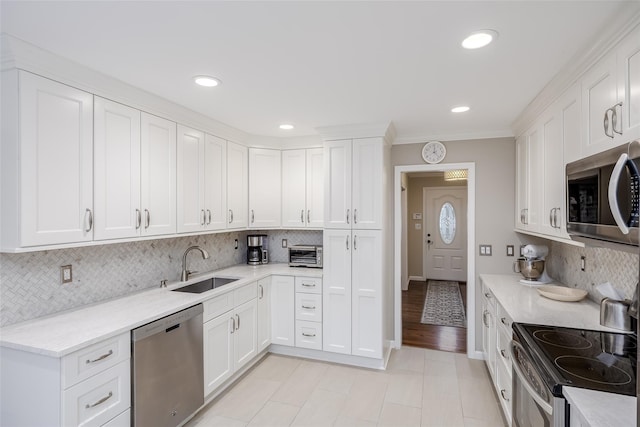 kitchen featuring white cabinets, backsplash, and appliances with stainless steel finishes