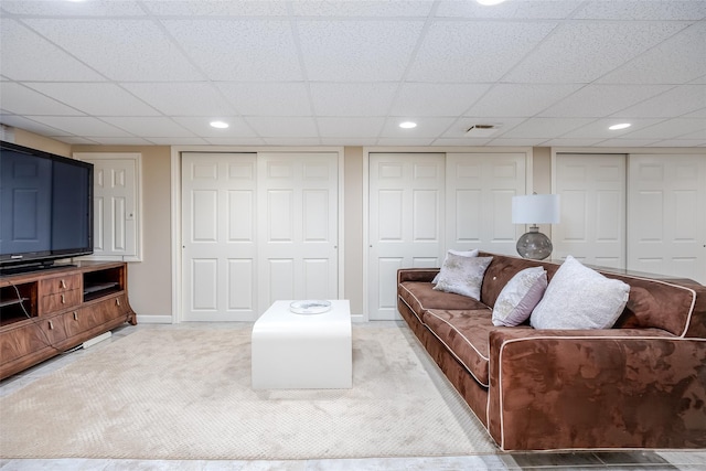 carpeted living room featuring a paneled ceiling