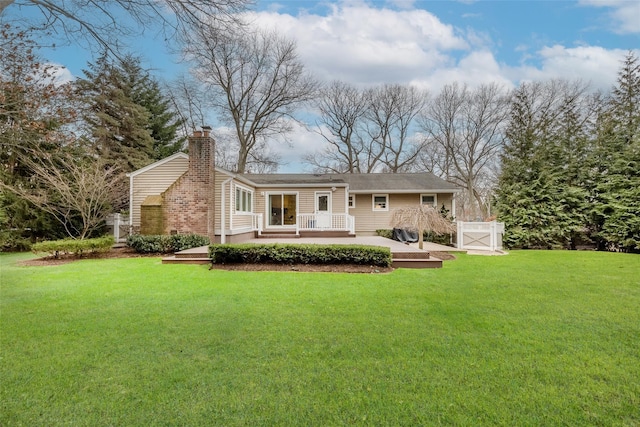 back of house featuring a deck and a lawn