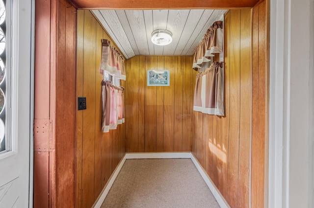 interior space featuring wood ceiling, carpet, and wood walls