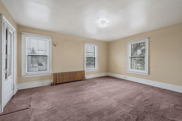 carpeted spare room featuring radiator heating unit