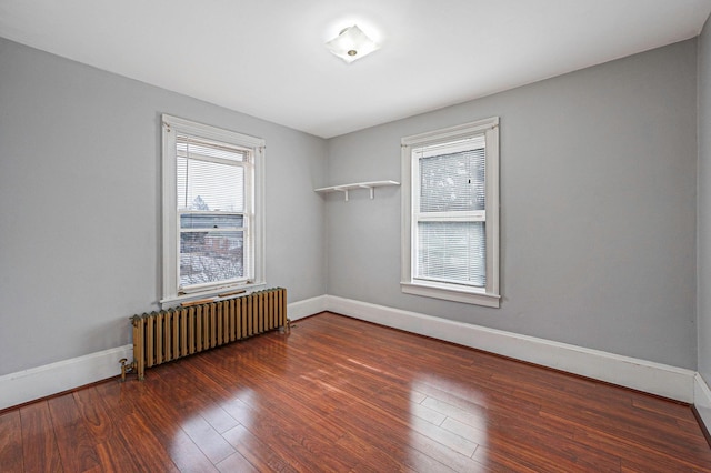 spare room with dark wood-type flooring and radiator heating unit