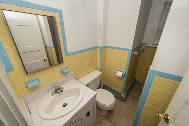 bathroom with vanity, toilet, tile patterned flooring, and tile walls