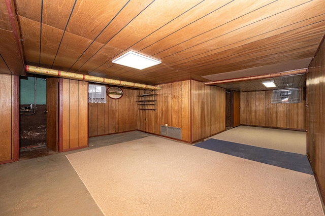 basement featuring wood ceiling and wood walls