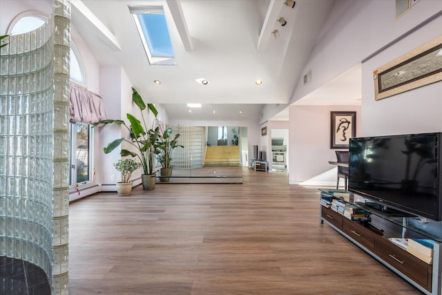 interior space featuring wood-type flooring, high vaulted ceiling, a baseboard heating unit, and a skylight