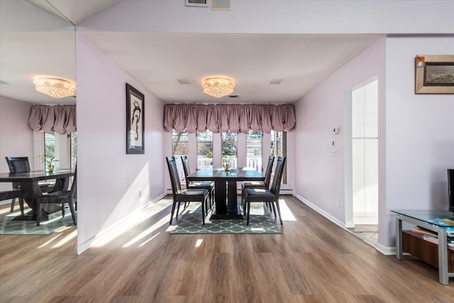 dining room featuring a wealth of natural light, hardwood / wood-style flooring, and a notable chandelier