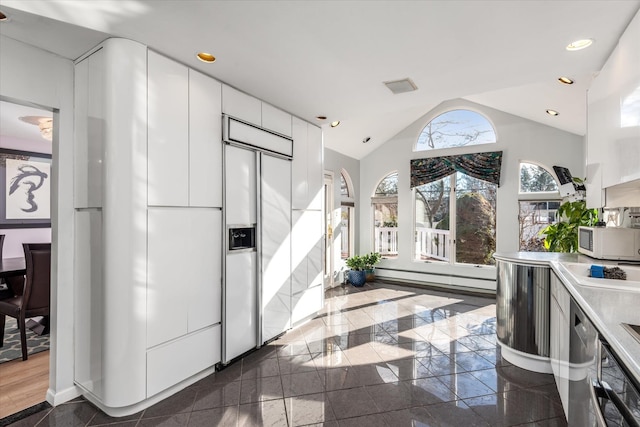 kitchen with paneled built in refrigerator, vaulted ceiling, a baseboard heating unit, white cabinetry, and stainless steel dishwasher