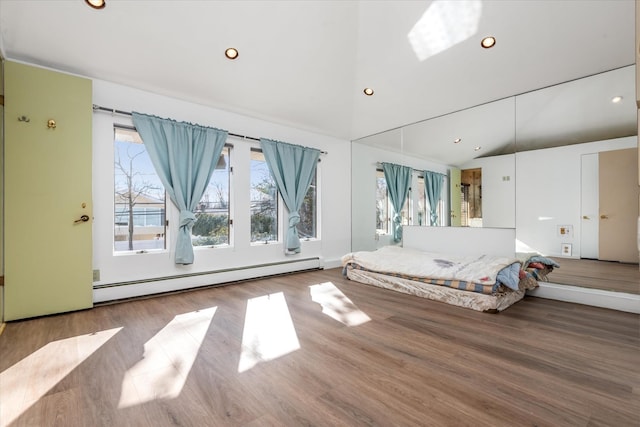 bedroom featuring vaulted ceiling, a baseboard radiator, and wood-type flooring