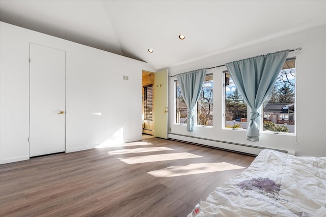 unfurnished bedroom with wood-type flooring, a baseboard heating unit, and vaulted ceiling