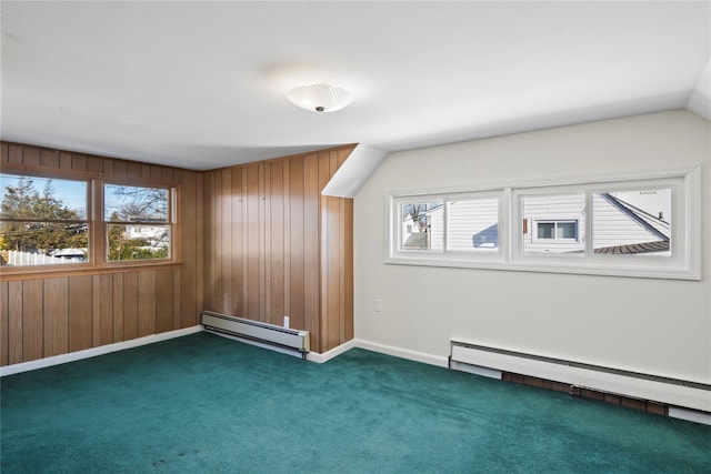 additional living space featuring vaulted ceiling, dark carpet, wooden walls, and baseboard heating