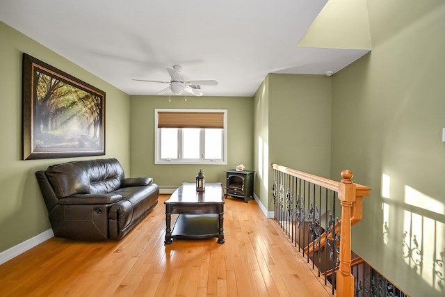 sitting room with a baseboard radiator, light hardwood / wood-style flooring, and ceiling fan