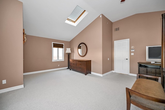 interior space with ceiling fan, vaulted ceiling with skylight, and carpet