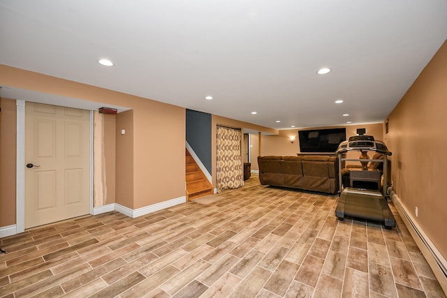 workout area with baseboard heating and light wood-type flooring