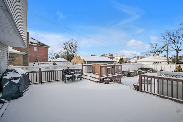 snow covered patio featuring a wooden deck