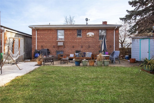 rear view of house with a lawn, a shed, a fire pit, and a patio