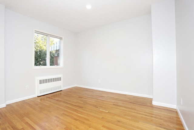 empty room with radiator and light hardwood / wood-style flooring