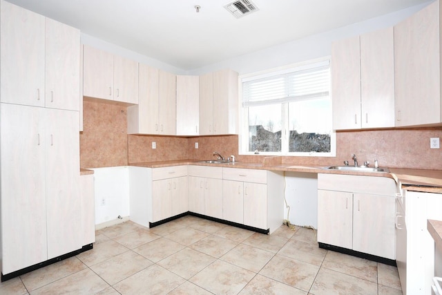 kitchen featuring sink, tasteful backsplash, and light tile patterned floors