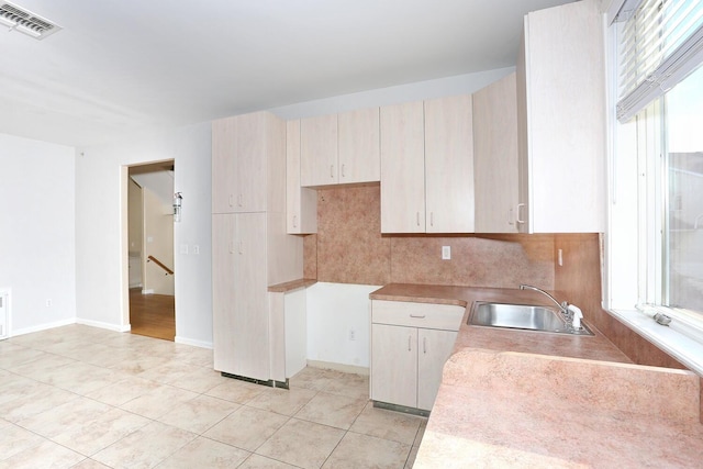 kitchen featuring sink, decorative backsplash, and light tile patterned floors