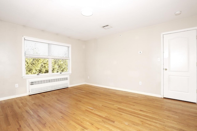 unfurnished room featuring light hardwood / wood-style floors and radiator