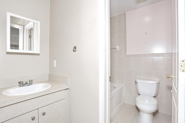 bathroom with tile patterned flooring, tile walls, toilet, a tub, and vanity