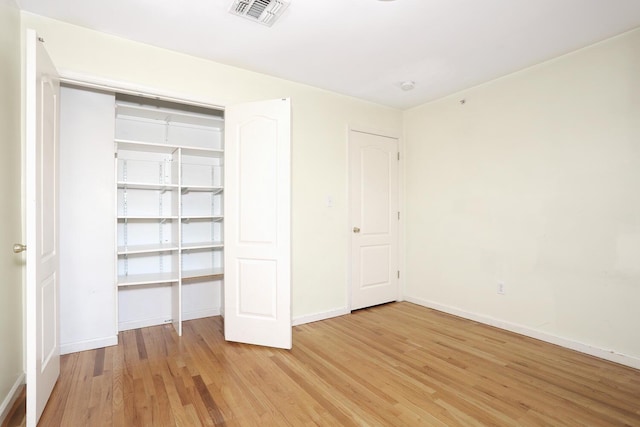 unfurnished bedroom with wood-type flooring and a closet