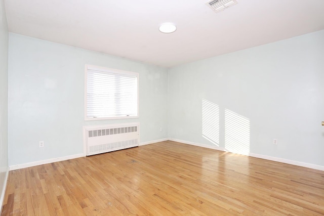 unfurnished room with light wood-type flooring and radiator