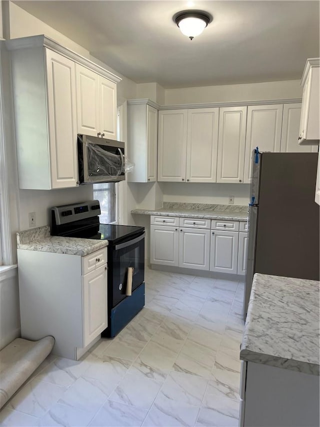 kitchen featuring white cabinets and appliances with stainless steel finishes