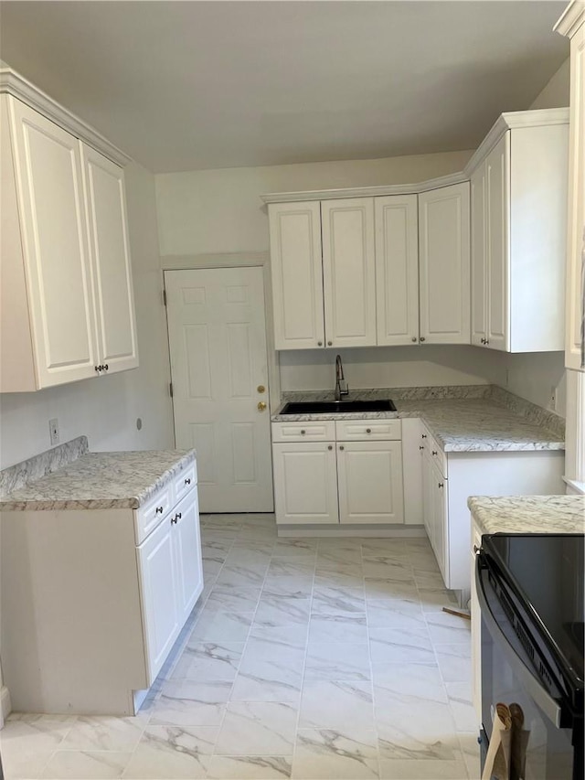 kitchen featuring white cabinetry and sink