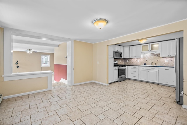 kitchen featuring white cabinetry, ceiling fan, stainless steel appliances, decorative backsplash, and sink