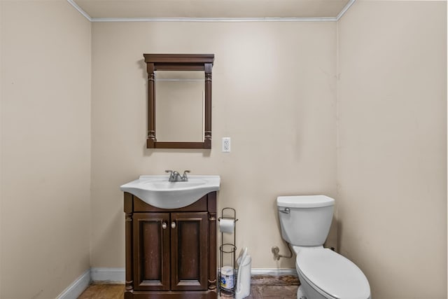 bathroom featuring toilet, ornamental molding, and vanity