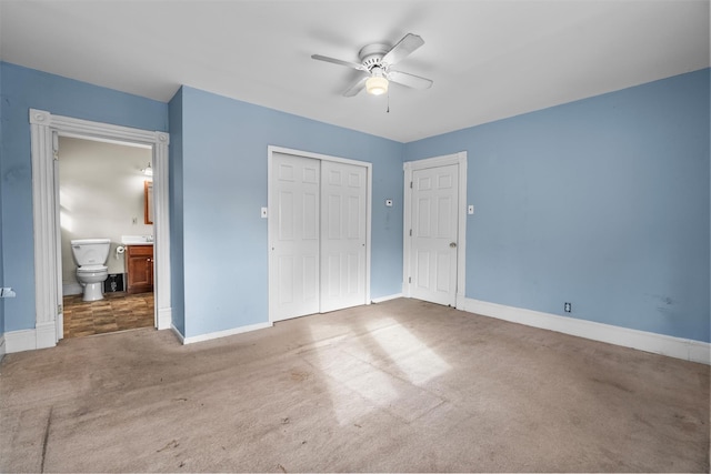 unfurnished bedroom featuring ceiling fan, ensuite bath, and carpet flooring