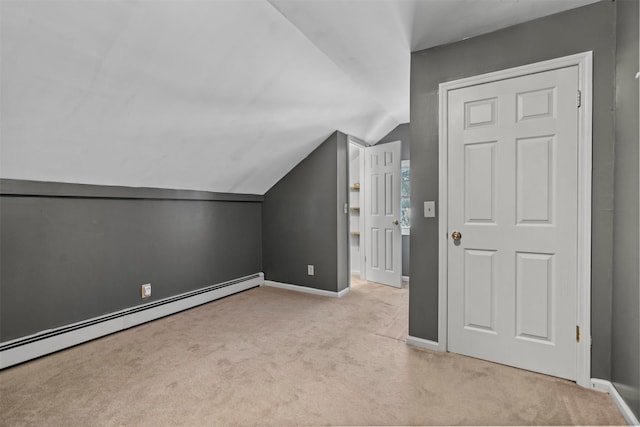 additional living space with baseboard heating, lofted ceiling, and light colored carpet