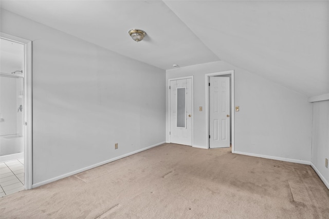 additional living space with light carpet and vaulted ceiling