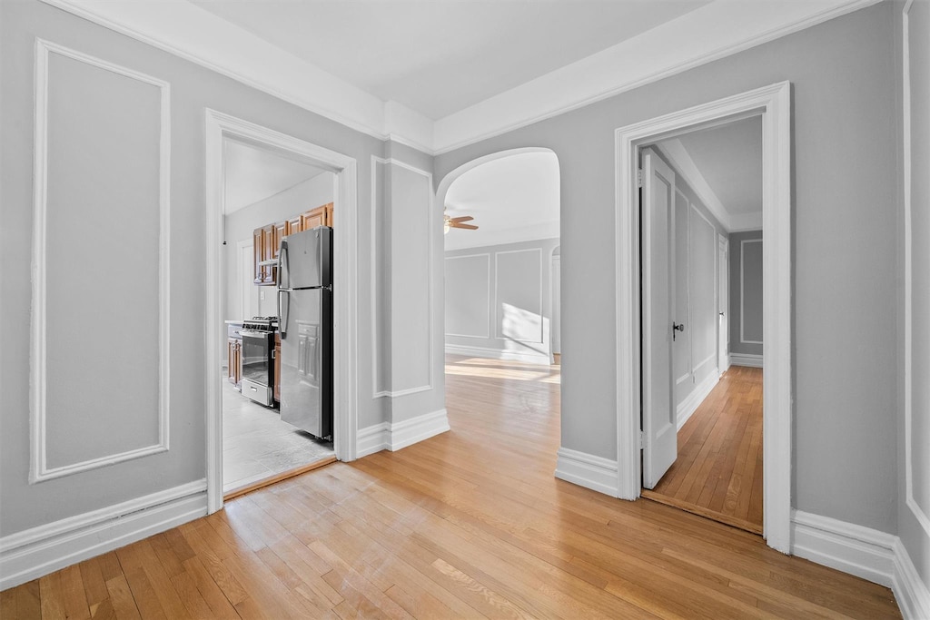 hallway featuring ornamental molding and light hardwood / wood-style flooring