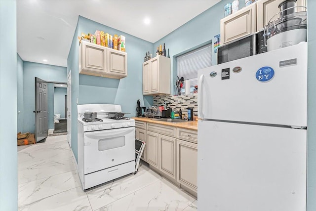 kitchen with decorative backsplash, sink, cream cabinetry, and white appliances