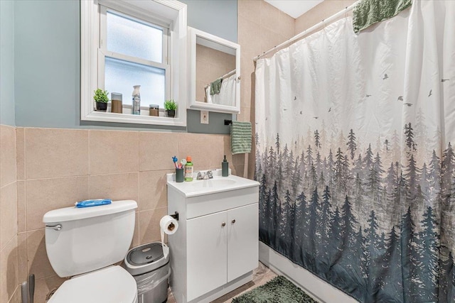 bathroom featuring toilet, vanity, tile walls, and a shower with curtain